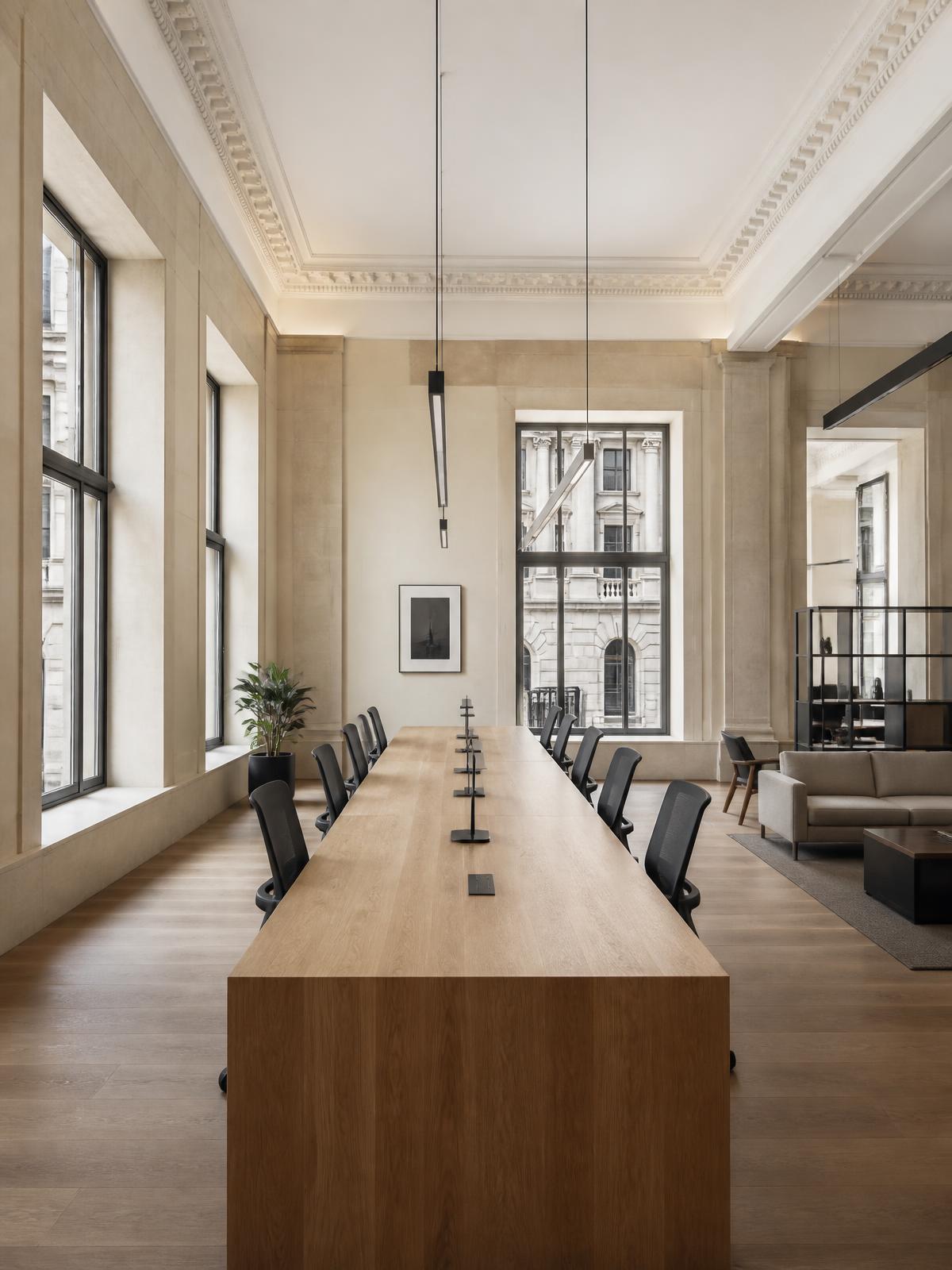 A bright London office fitted by Trademark Interiors, with a long communal oak table and charcoal task chairs